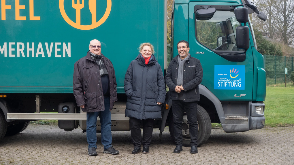 Das Foto zeigt  Thorsten Büsker, Silke Rupietta und Amgad Abdelmoniem, die vor einem Transporter der Tafel Bremerhaven stehen